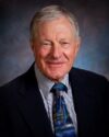 A man in a suit and tie smiling for the camera.